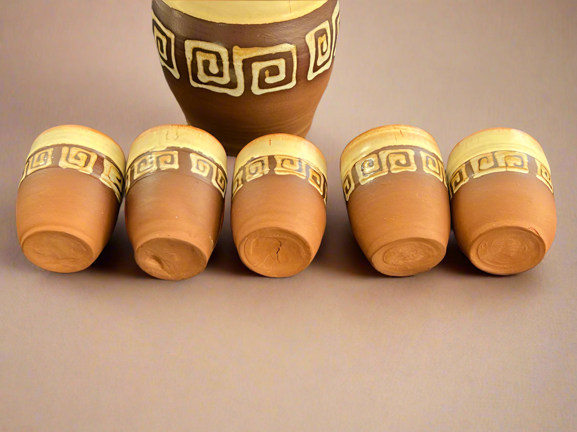 Set of six wooden cups with decorative patterns on a dark fabric background