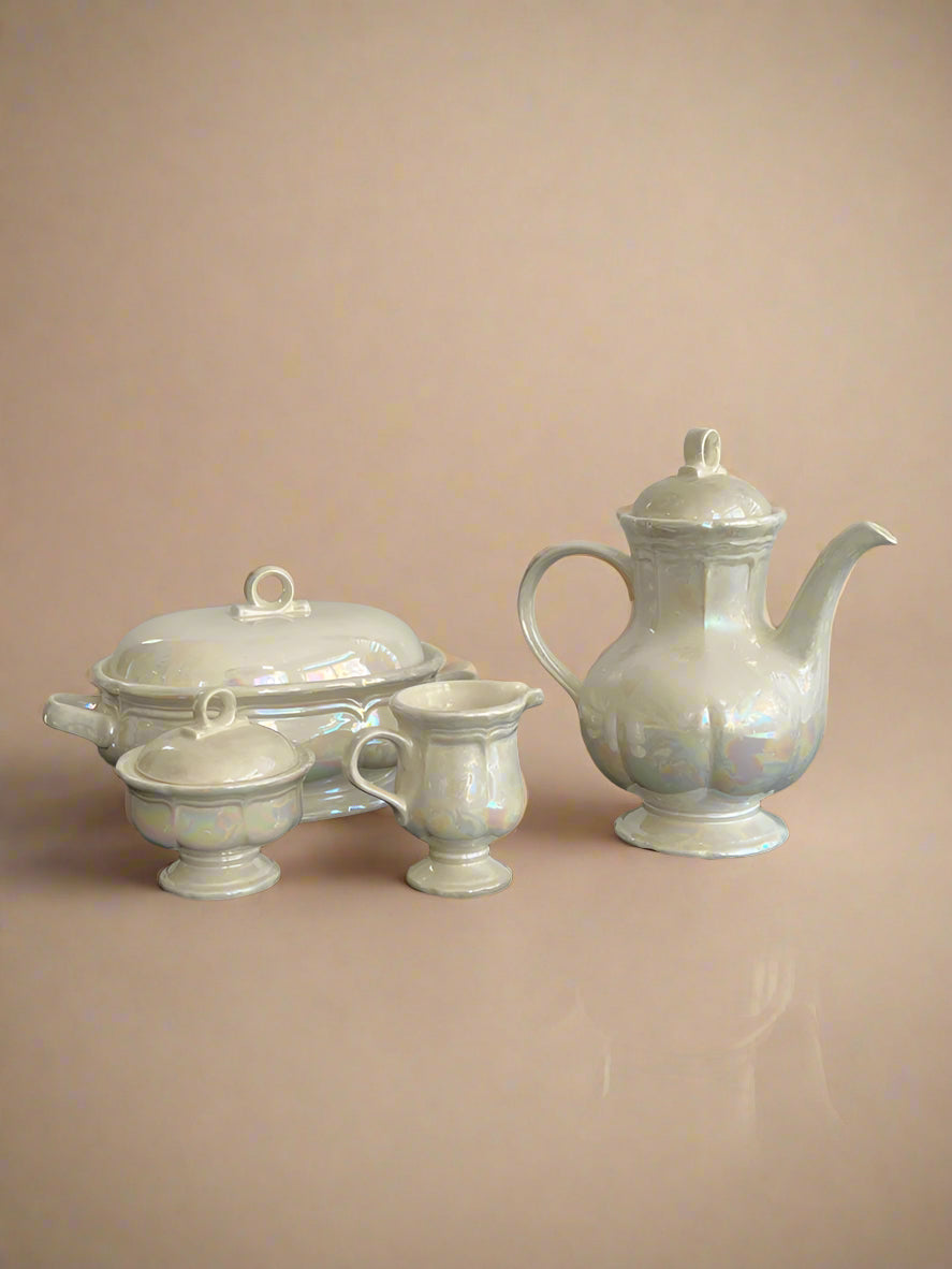 Set of white ceramic teaware on a black surface with a gray background
