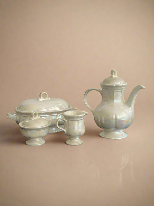 Set of white ceramic teaware on a black surface with a gray background